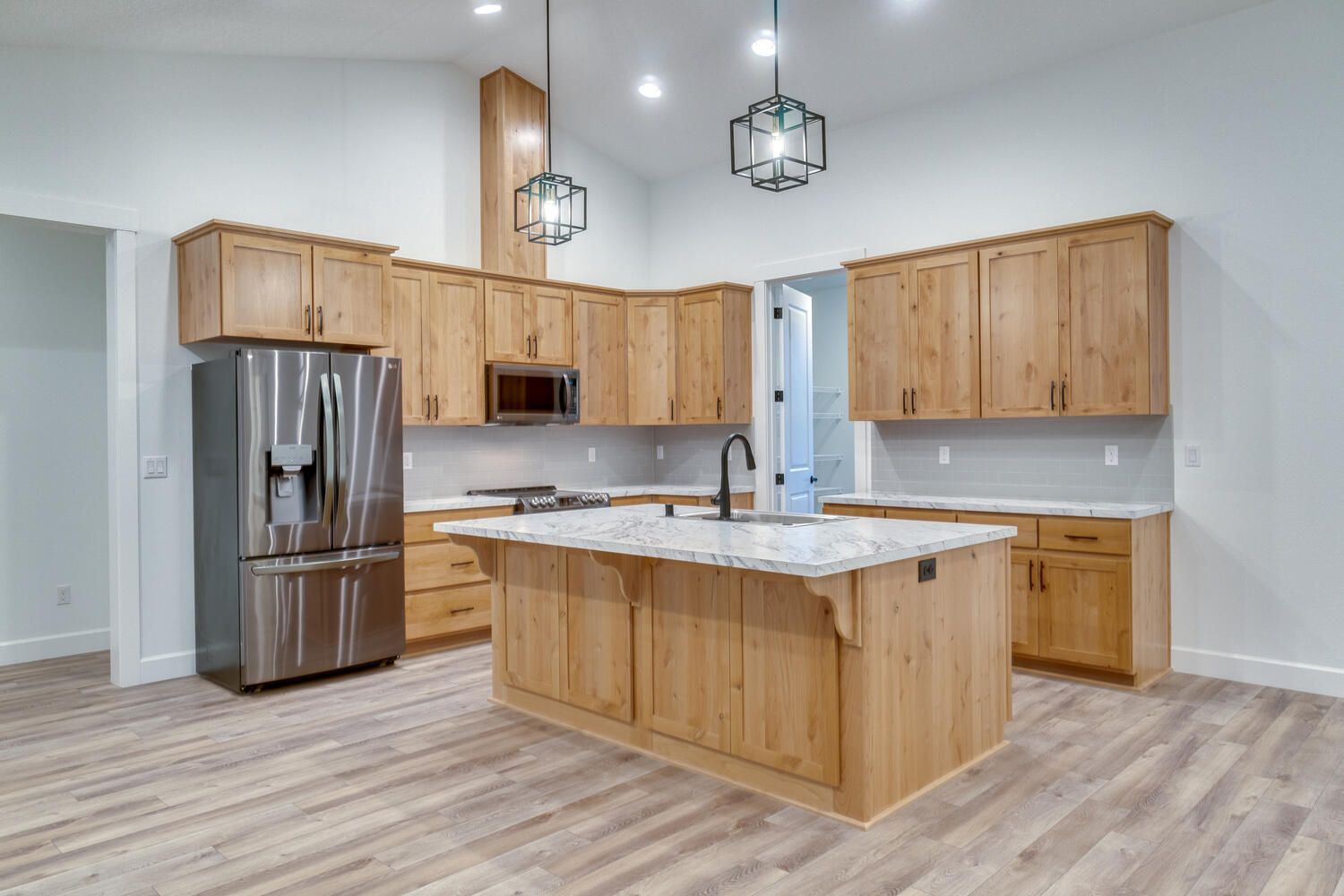 A kitchen with wooden cabinets , stainless steel appliances , and a large island.