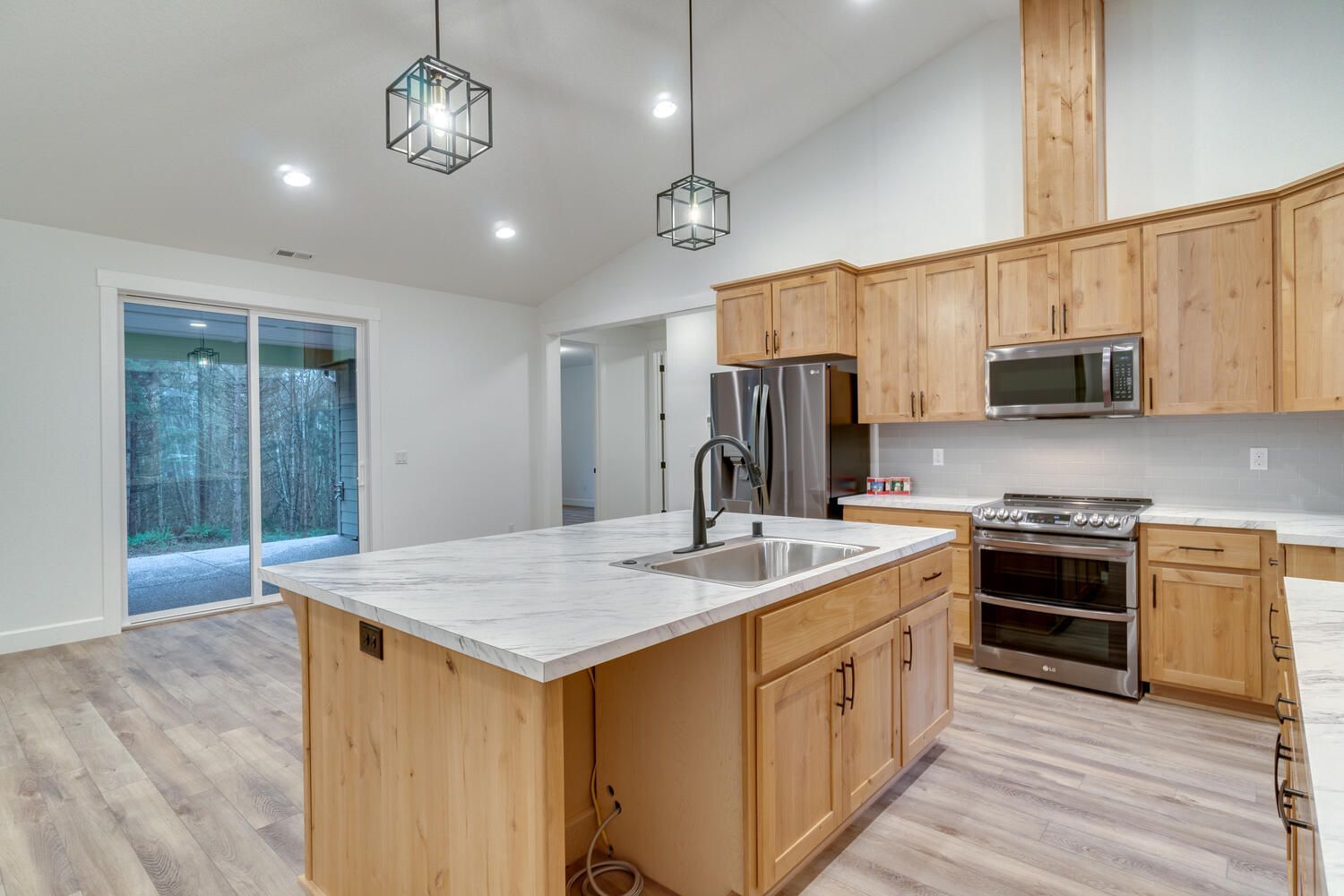 A kitchen with wooden cabinets , stainless steel appliances , and a large island.
