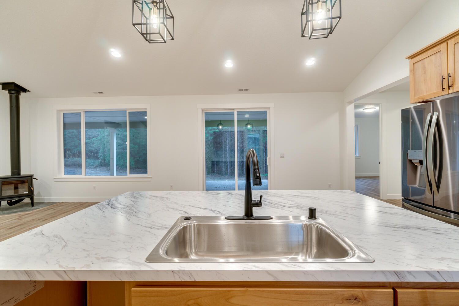 A kitchen with a stainless steel sink and a marble counter top.
