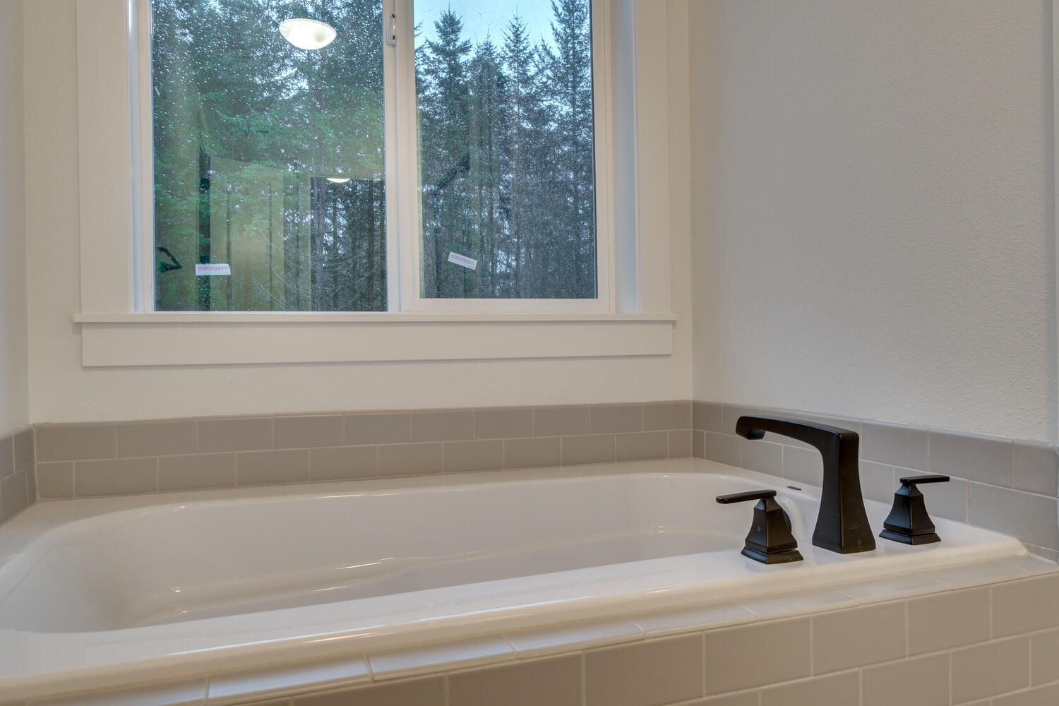 A bathtub in a bathroom next to a window.