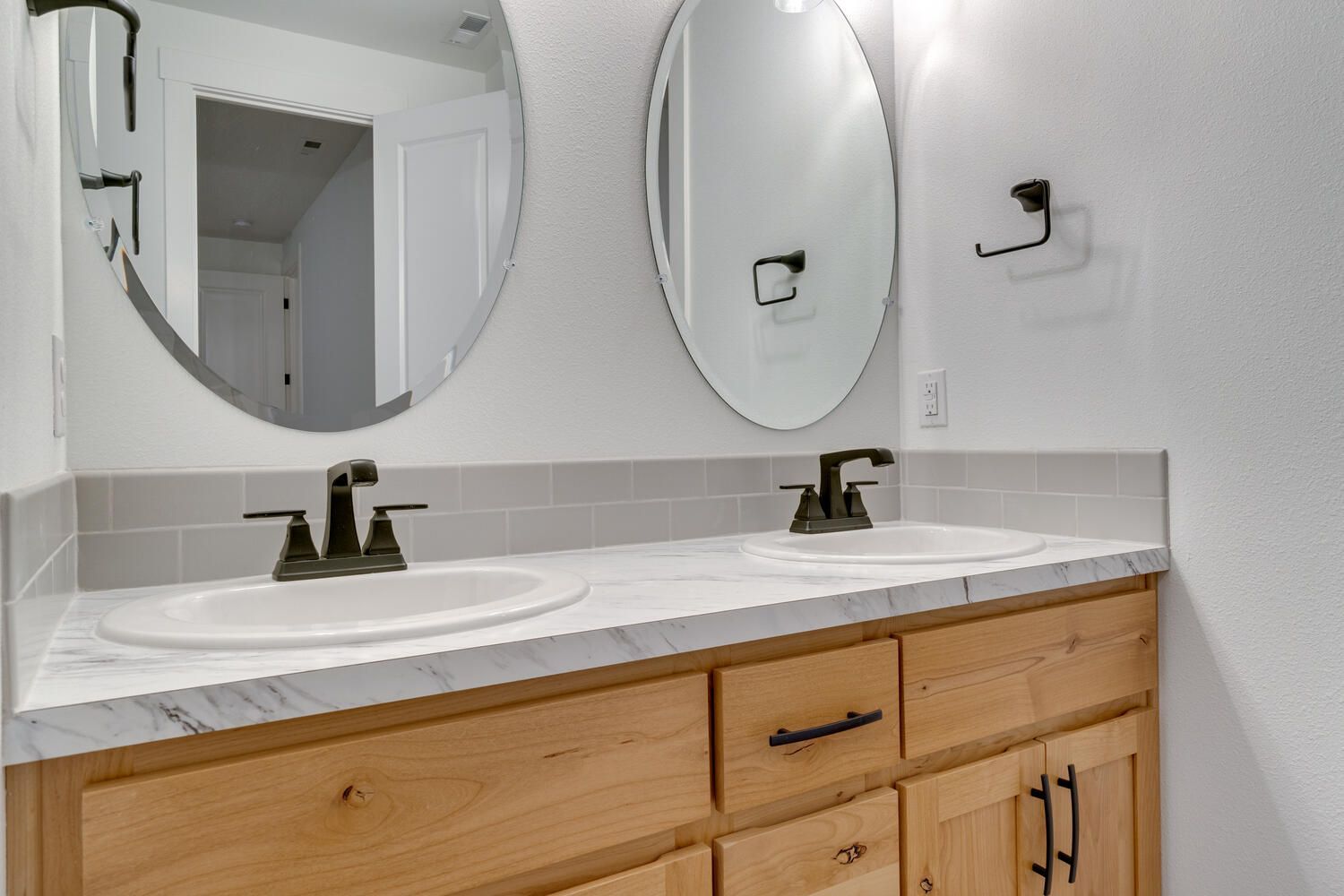 A bathroom with two sinks and two mirrors.