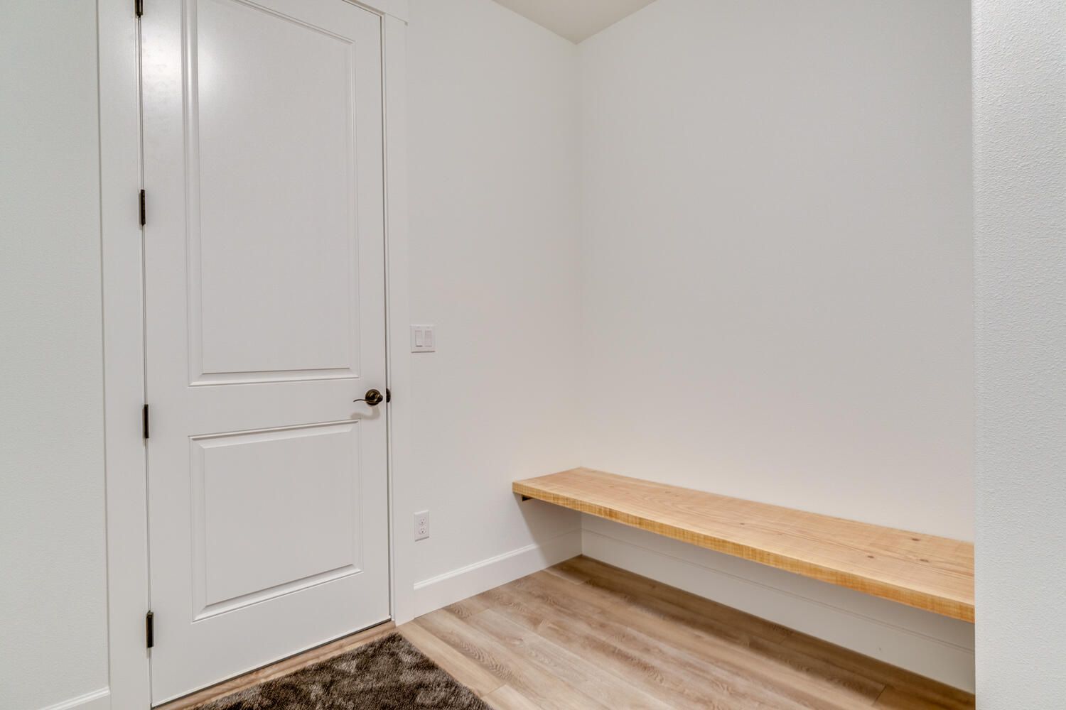 There is a bench in the corner of the room.