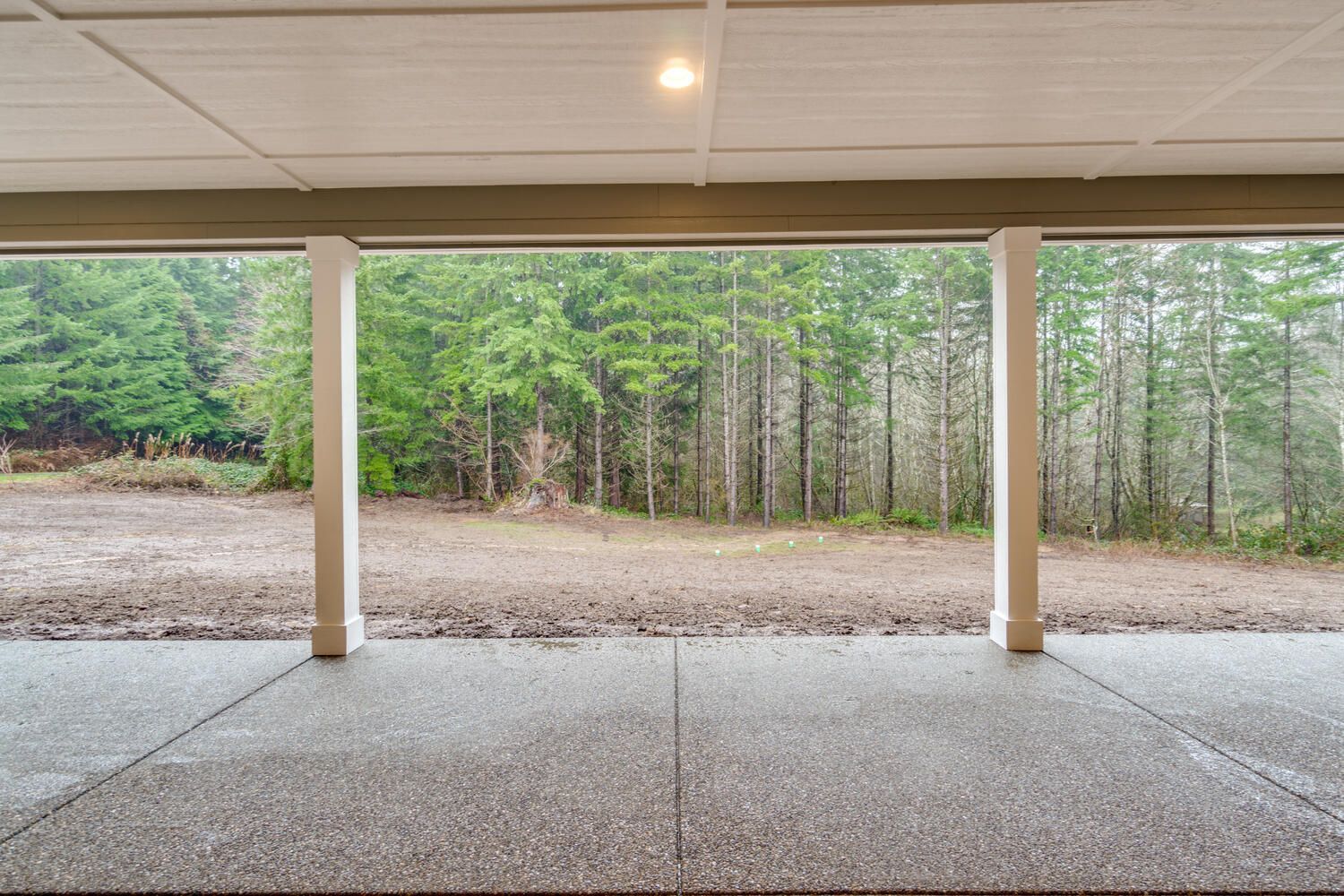 An empty garage with a view of a forest.