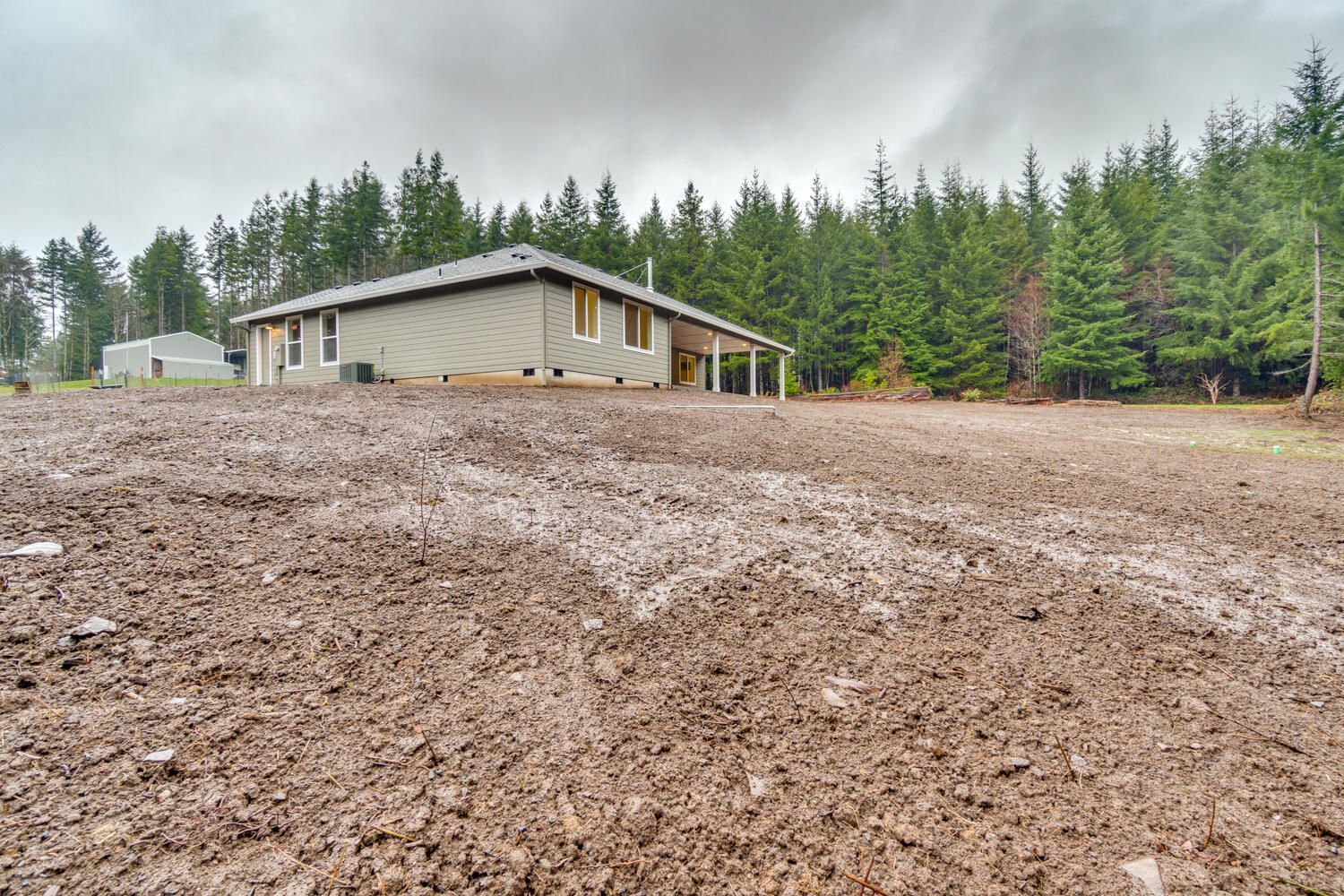 A muddy field with a house in the background