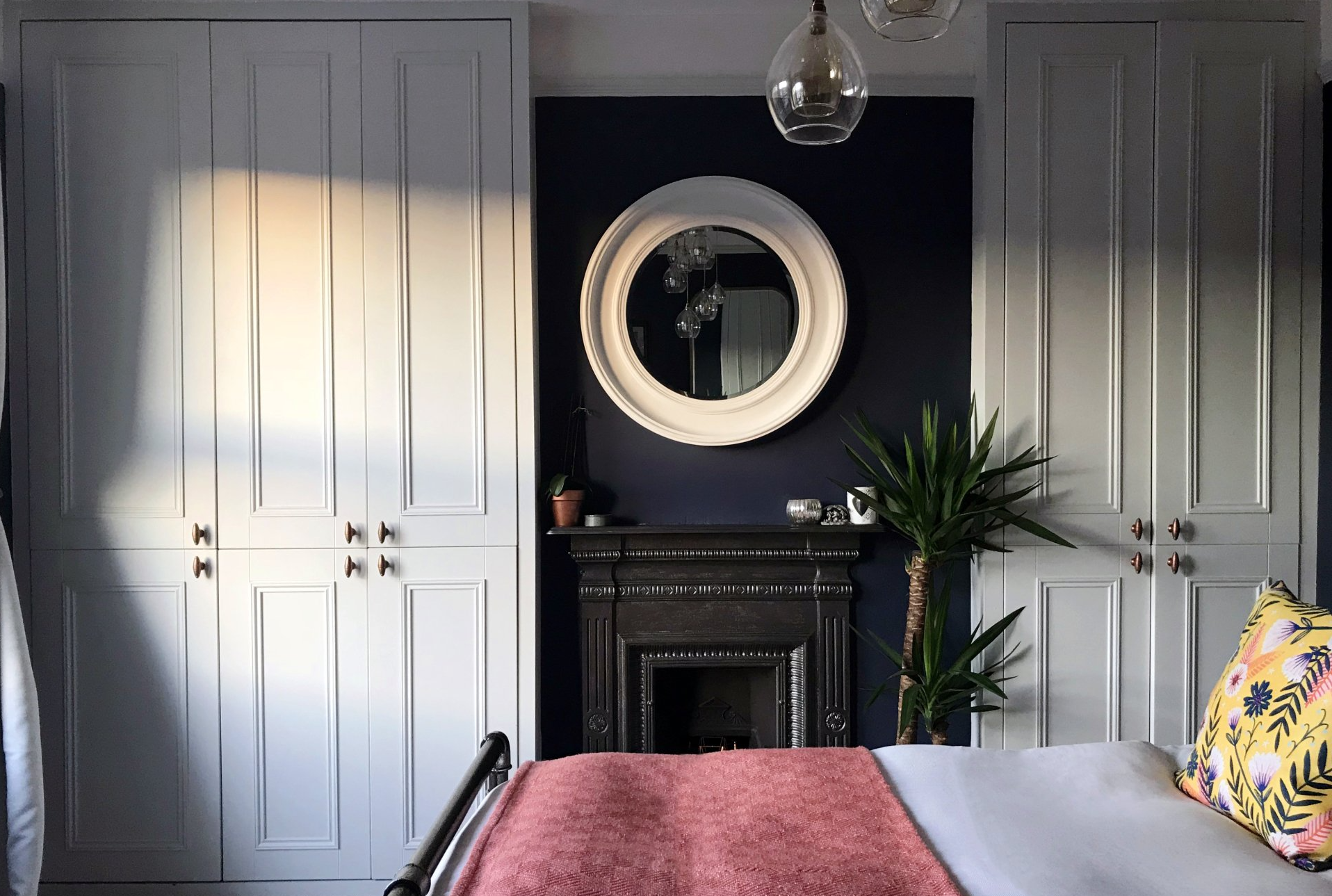 renovated bedroom with dark blue feature wall and mirror