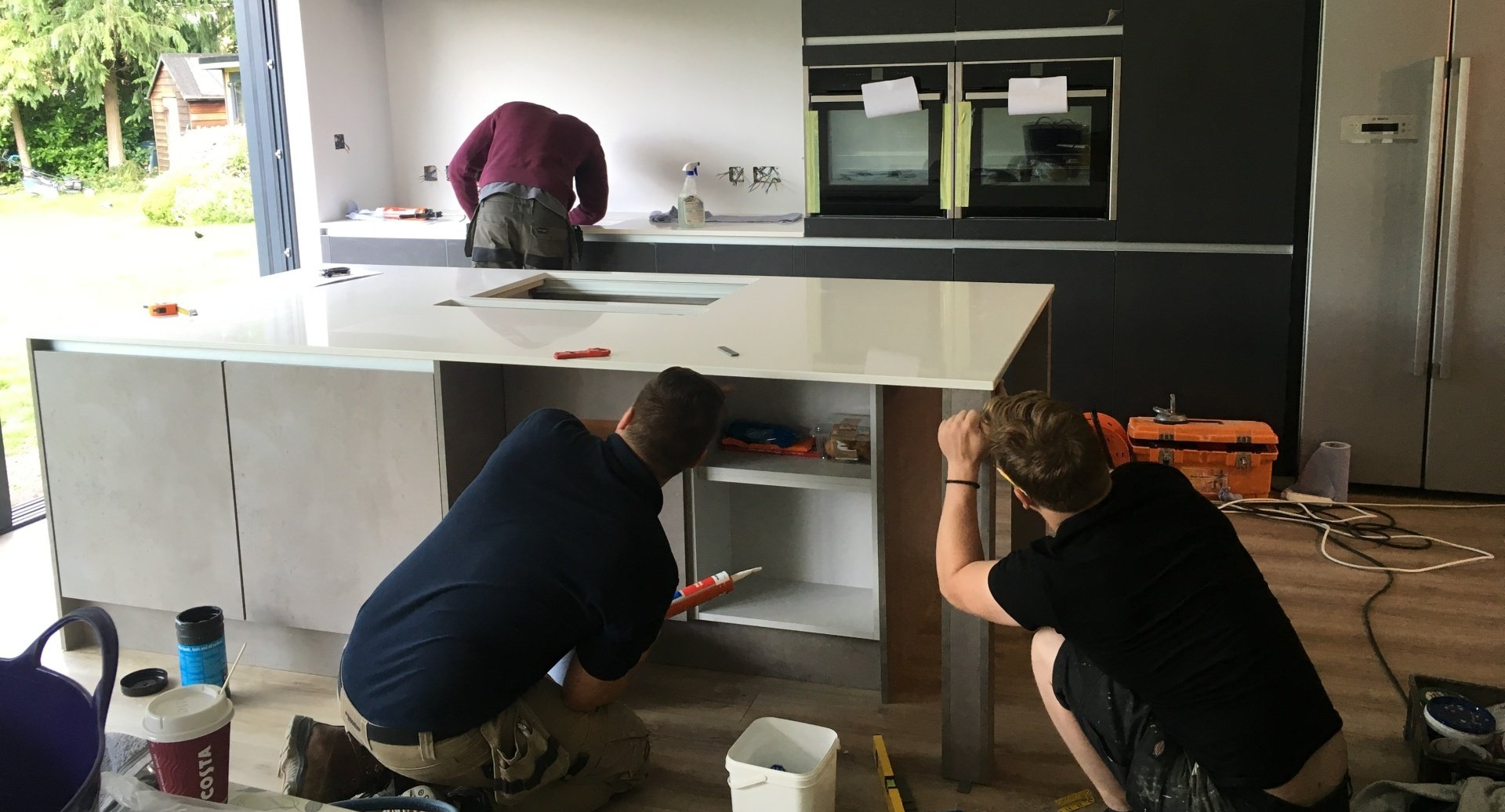 three men at work creating a kitchen island unit