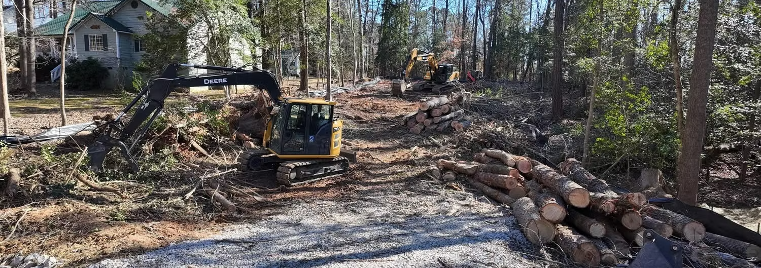 Excavators clearing and preparing wooded land for a new construction or development project.