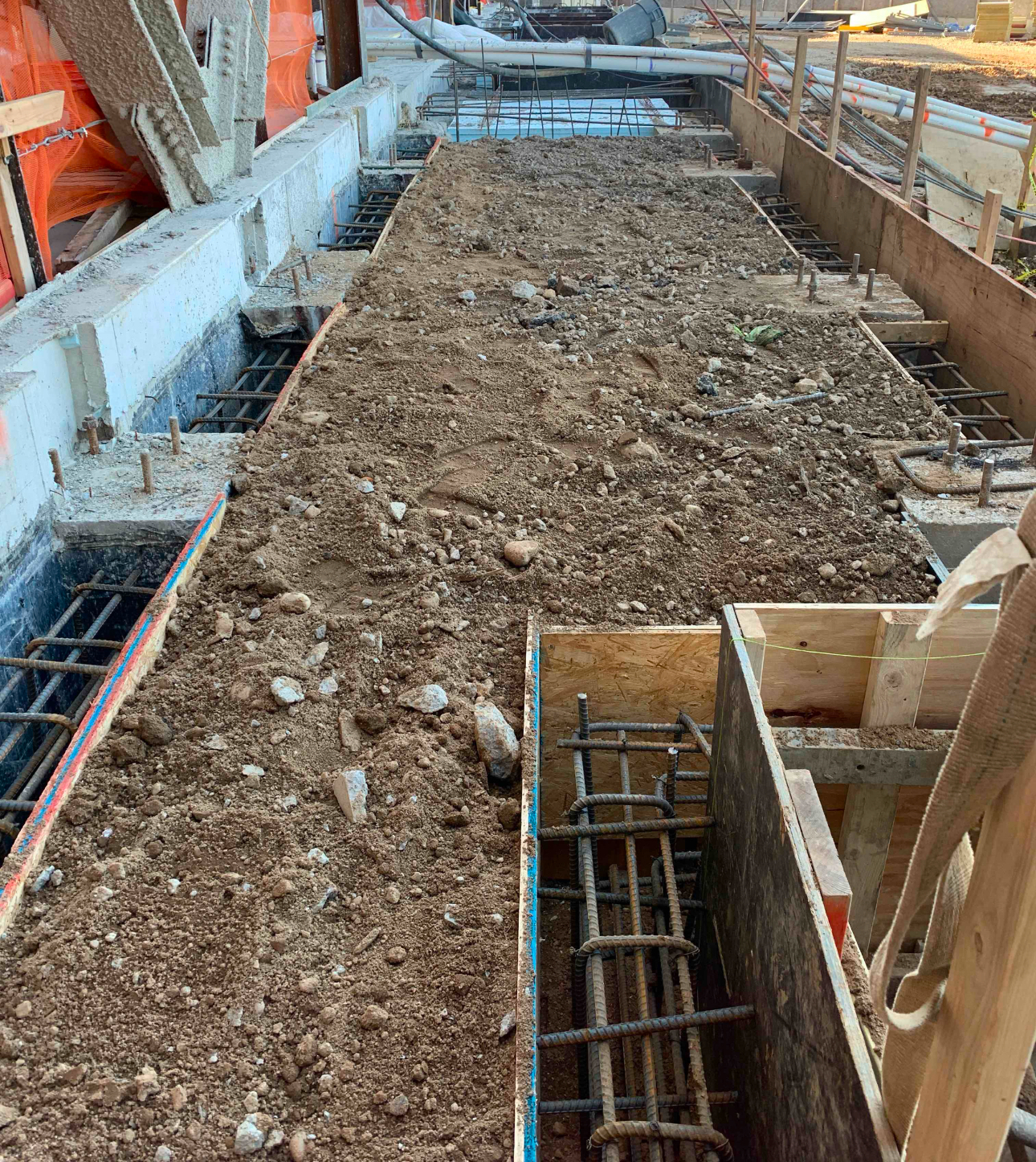 Foundation formwork with soil preparation underway for concrete pouring and structural support.