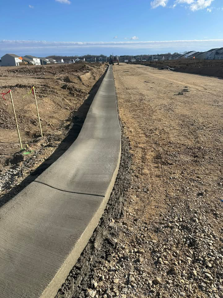 New concrete sidewalk and roadway being installed as part of a neighborhood development project.