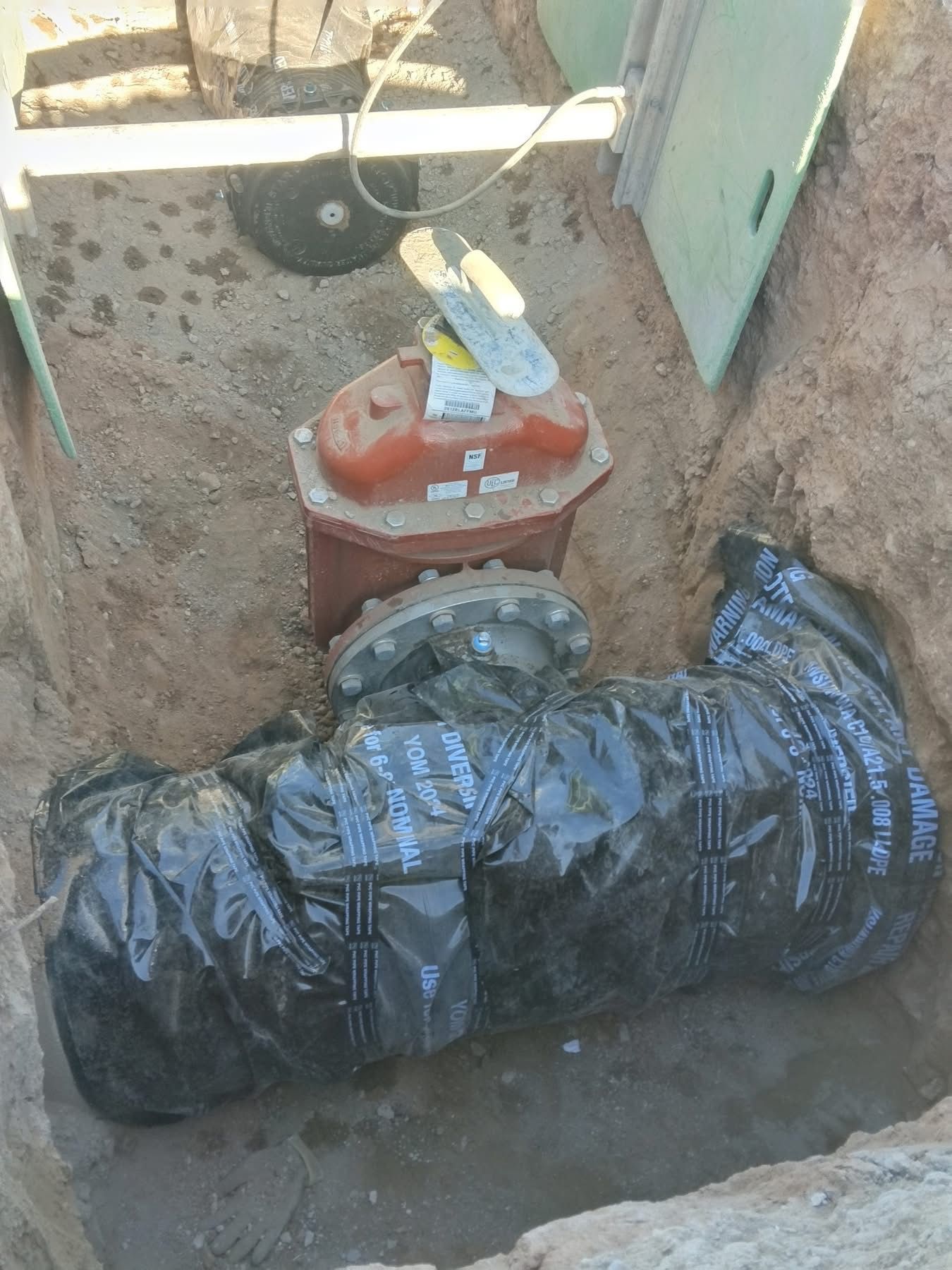 Utility conduits and control box installation during underground electrical or water system setup.