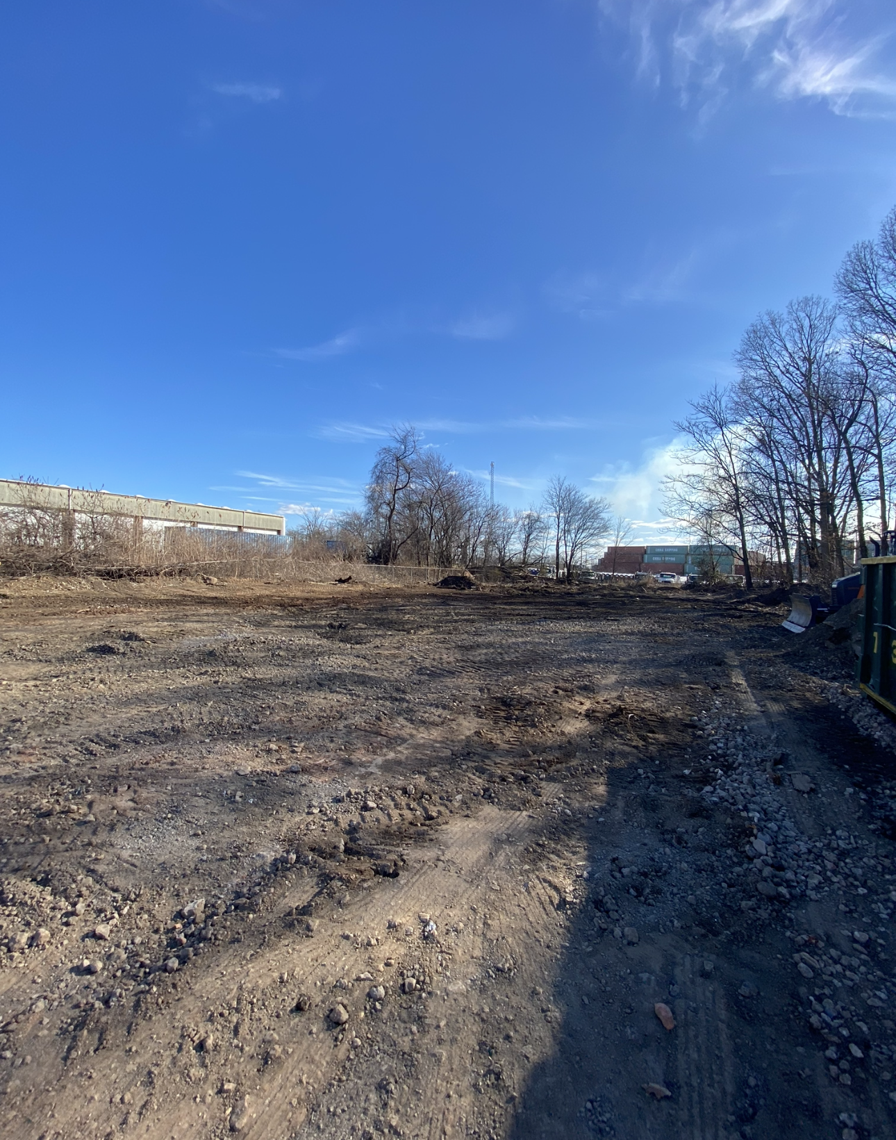 Clear blue sky over an active construction site prepared for excavation and infrastructure work.