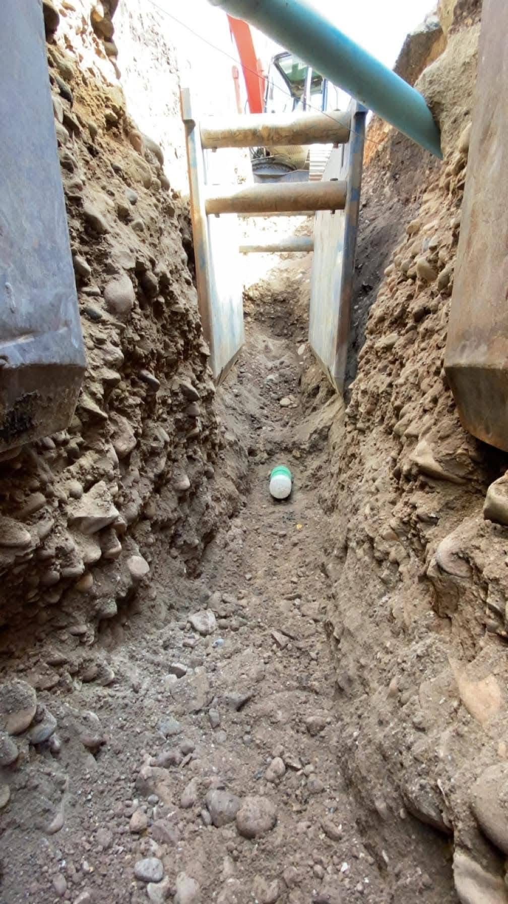 View inside a utility trench showing installed piping and structural support for underground systems.