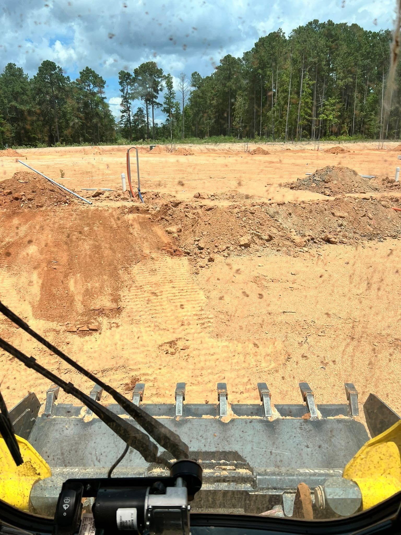 Level construction site with groundwork complete and utility lines ready for installation.