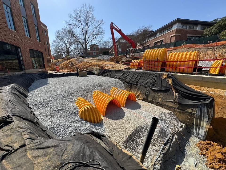 Construction site with stormwater retention system components staged for installation.