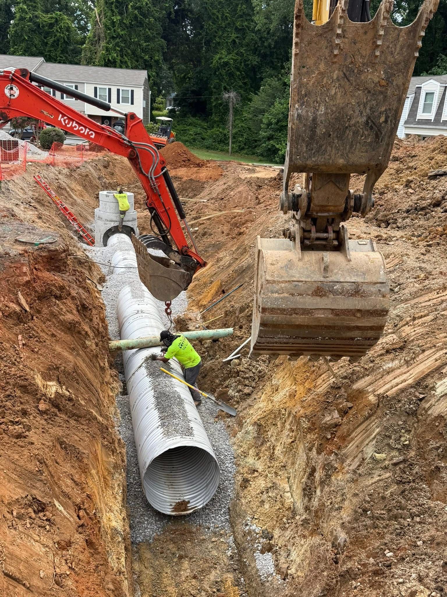 Excavator digging trench for water, sewer, or utility line installation on a residential project site.