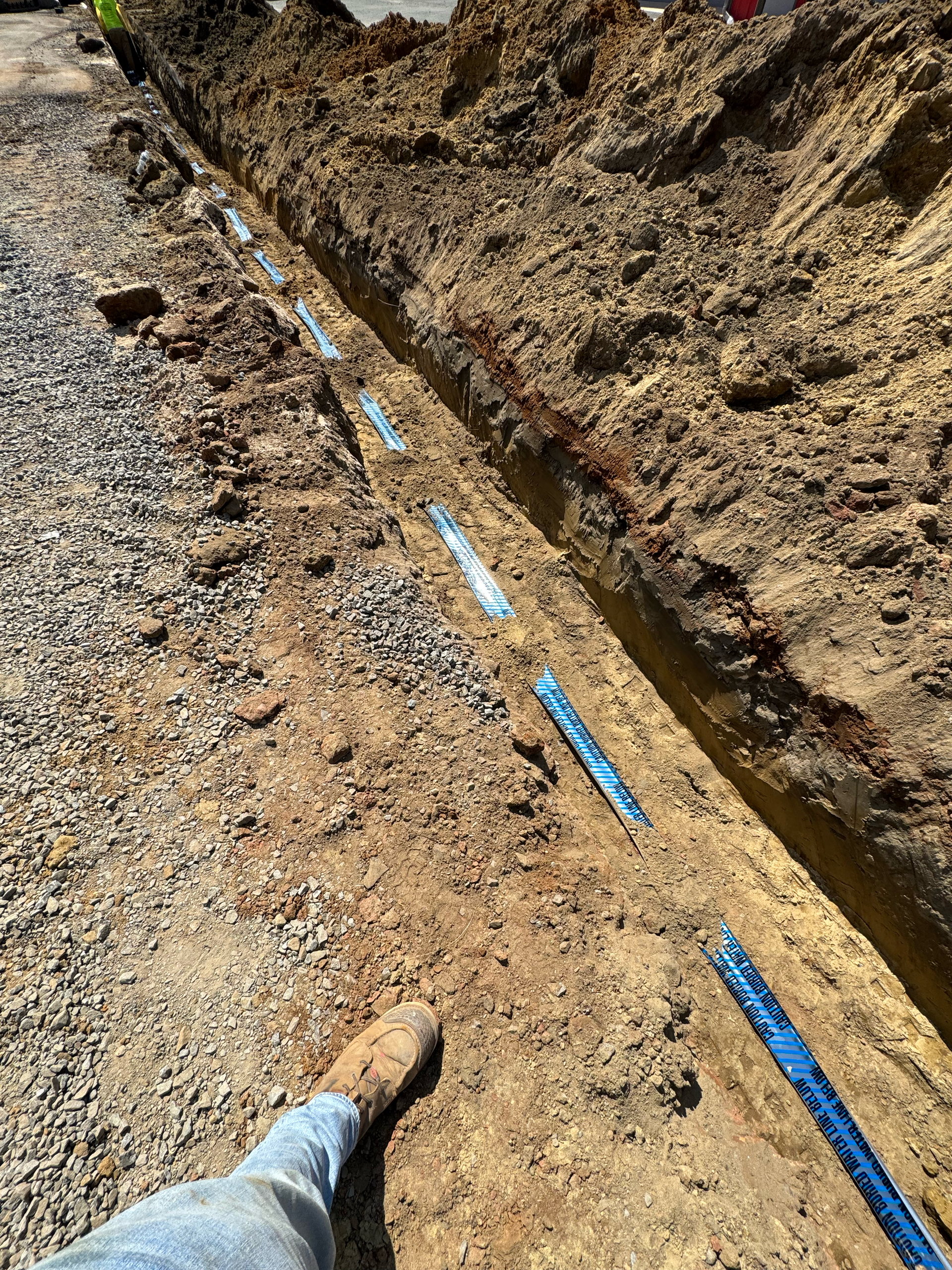 Excavated utility trench prepared for underground piping, drainage, or electrical infrastructure installation.