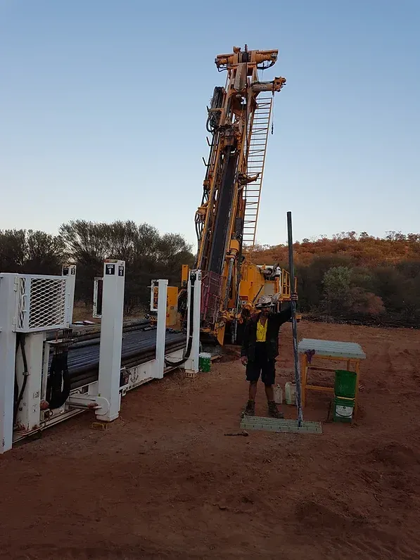 Man in Full Personal Protective Equipment Alongside Heavy Machinery at the Site — Grid Drilling in Munduberra, QLD