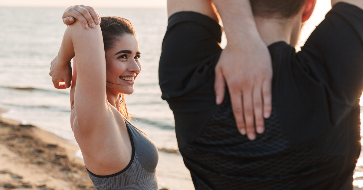 Young couple stretching, symbolizing connection between fitness and personalized concierge wellness