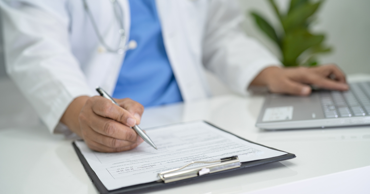 Concierge doctor completing patient intake form while using a laptop in Las Vegas clinic
