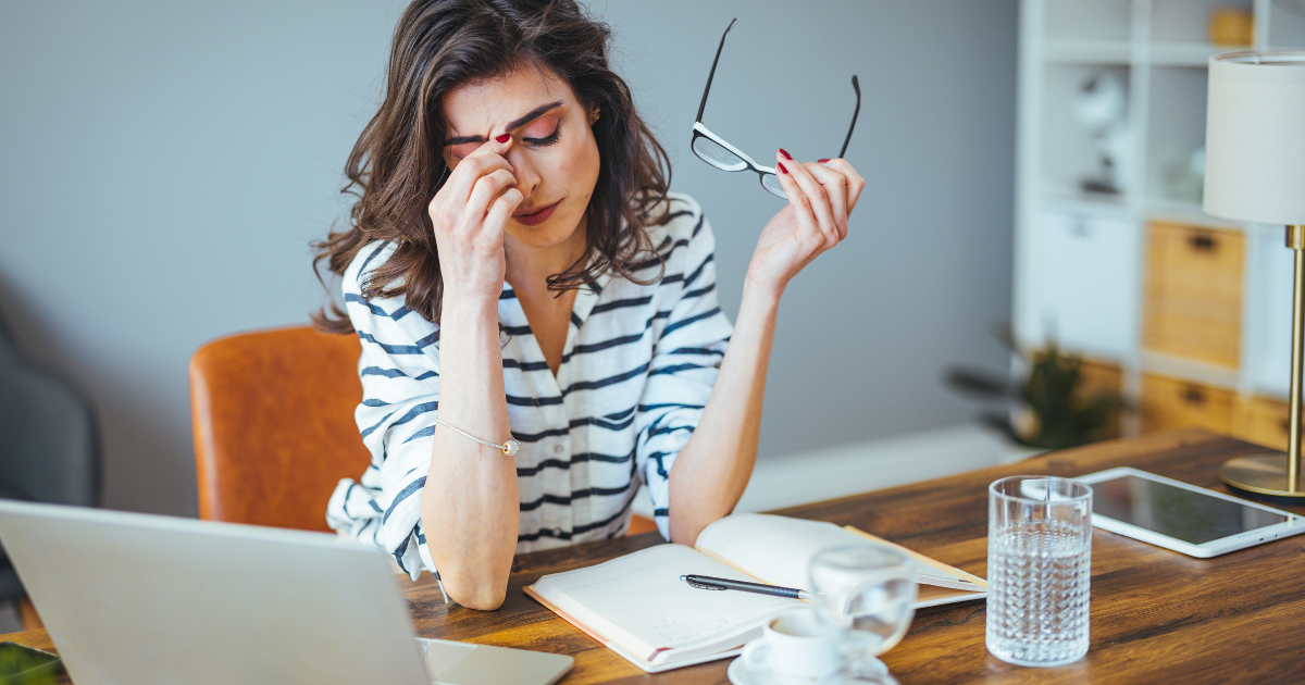 Stressed professional woman at desk representing executive burnout and need for concierge healthcare