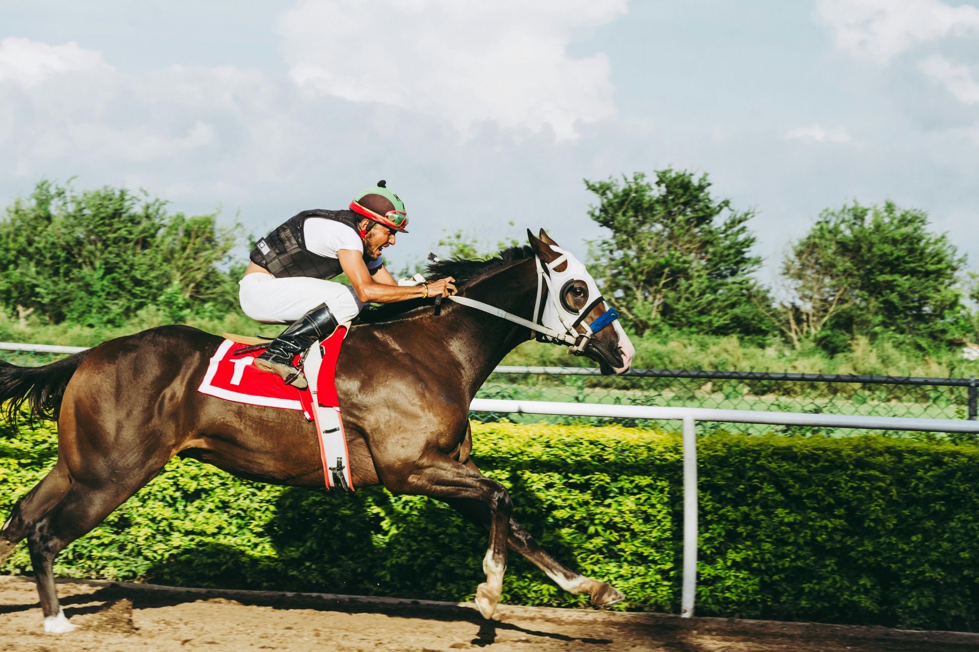 A jockey is riding a horse on a race track.