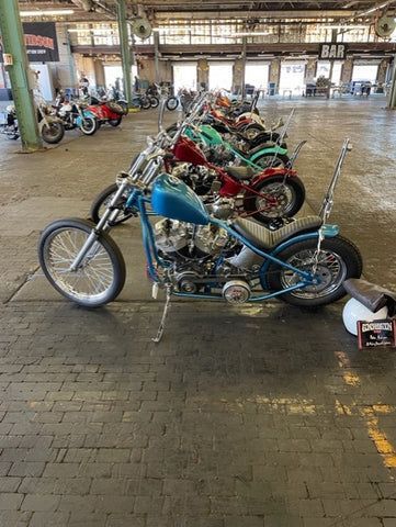A row of motorcycles are parked in a warehouse.