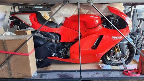 A red ducati motorcycle is sitting on top of a table.