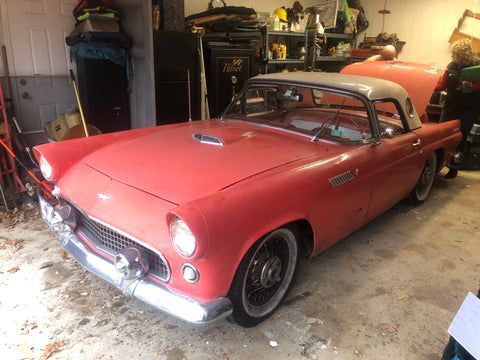 A red ford thunderbird is parked in a garage.