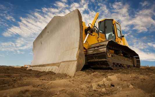 A bulldozer is moving dirt on a construction site.