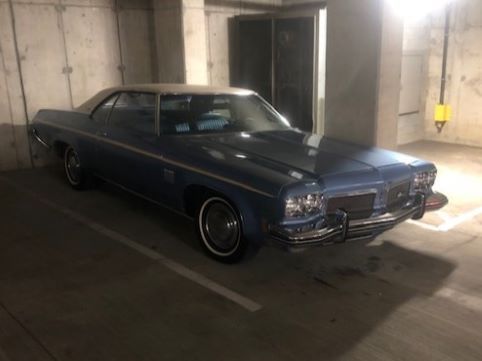 A blue car is parked in a parking garage.