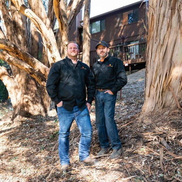 Michael and Gustavo of Arbor Vision are standing next to each other in front big trees.