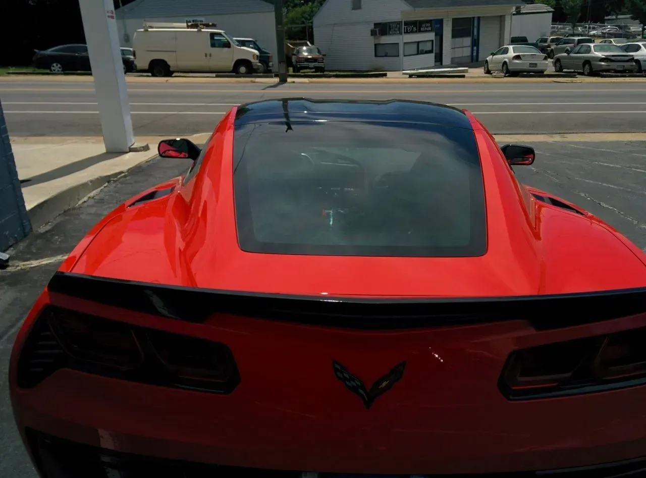 A red sports car is parked on the side of the road.