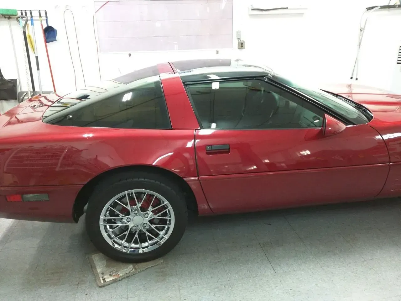 A red sports car is parked in a garage.