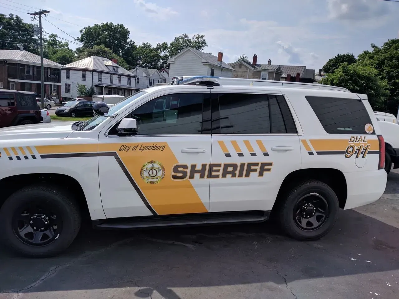 A white and yellow sheriff 's car is parked in a parking lot.