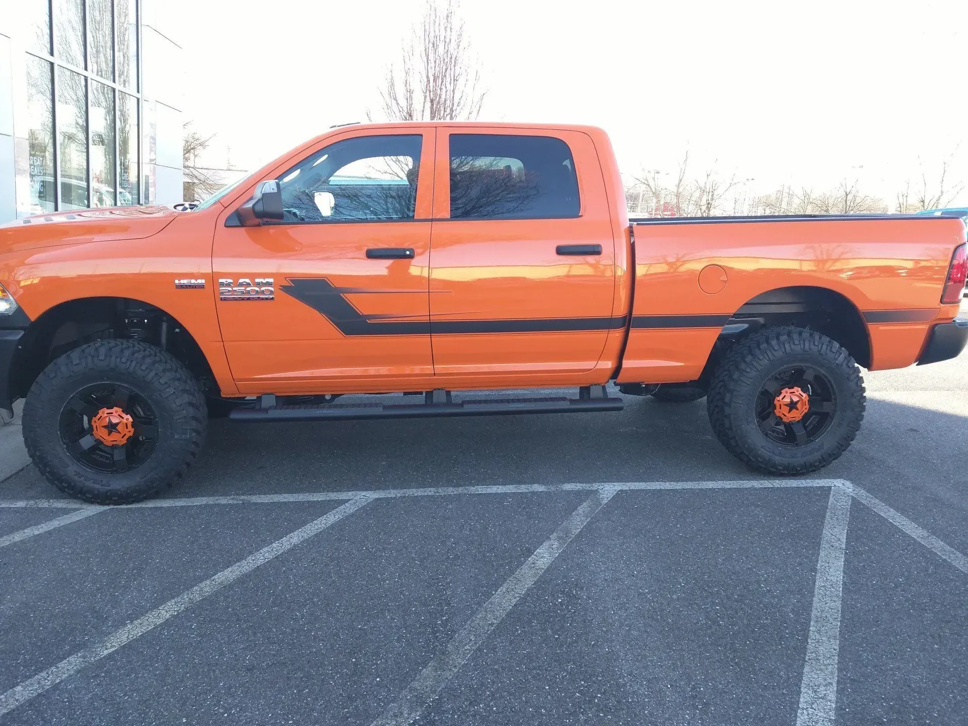 An orange ram truck is parked in a parking lot.