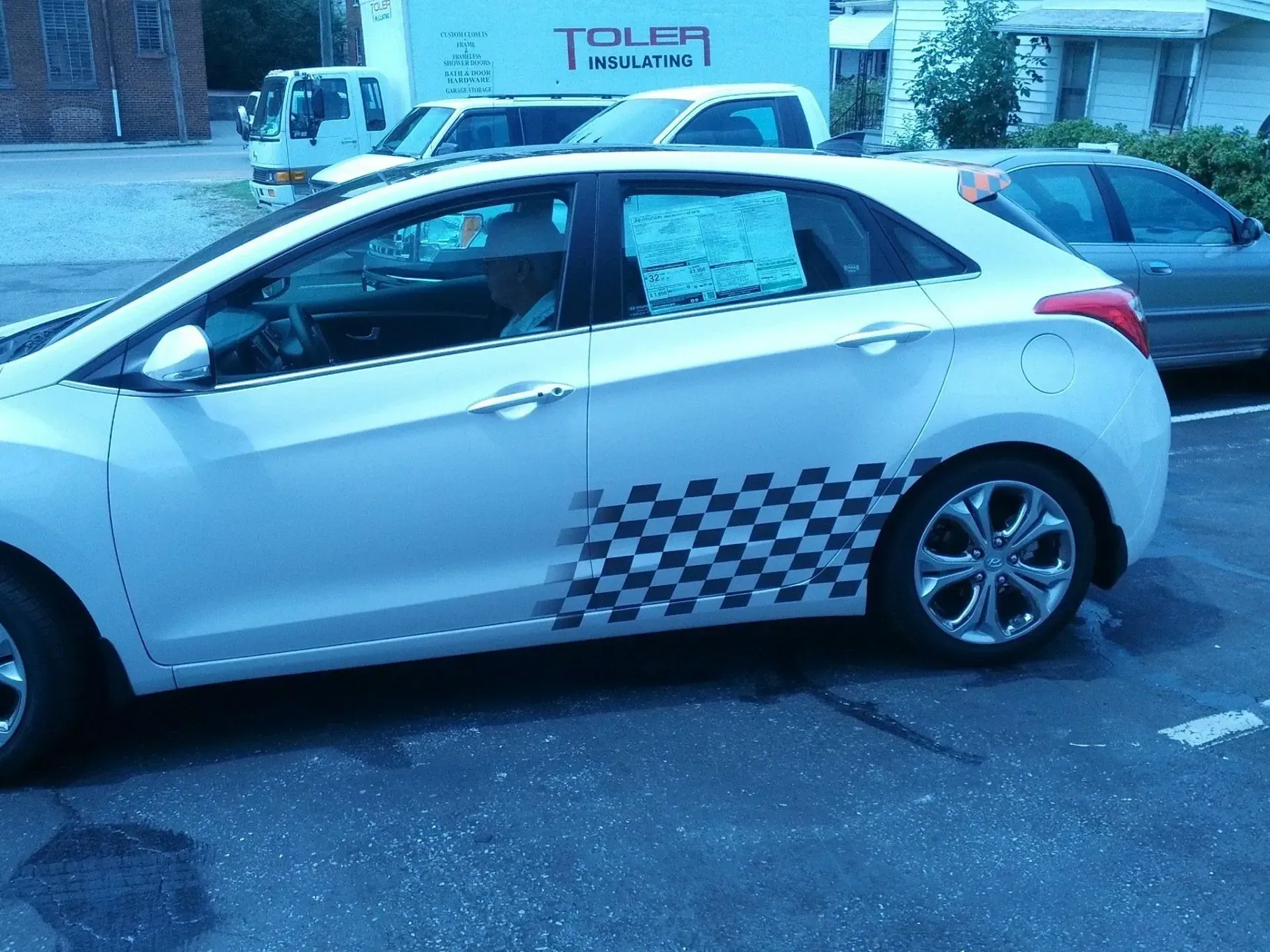 A white car is parked in front of a toler truck.