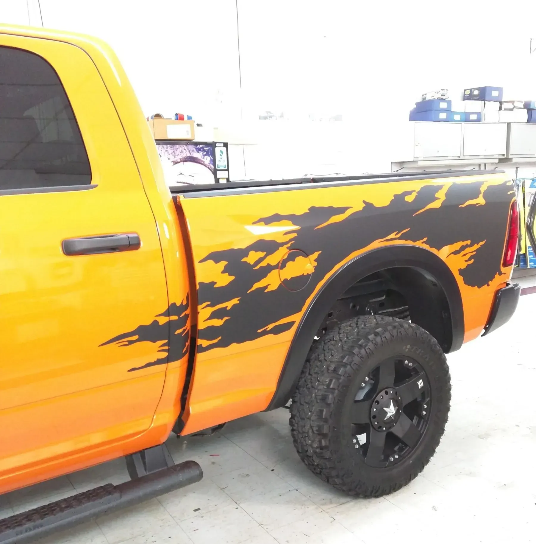 An orange truck with a black stripe on the side.