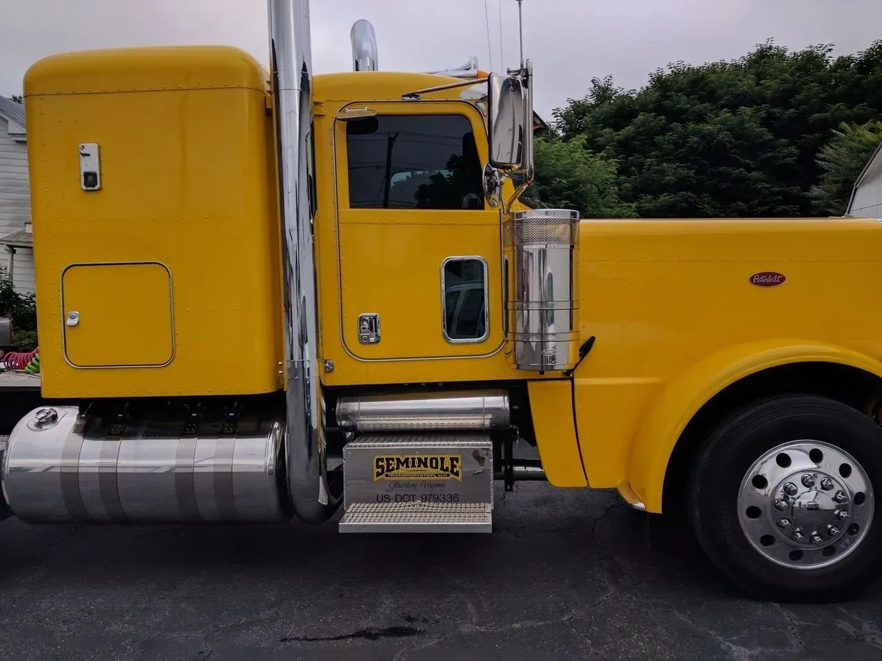 A yellow semi truck is parked in a parking lot.