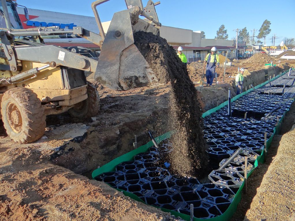 Bulldozer is Pouring Dirt into a Trench — Mawson Constructions in Kialla, VIC