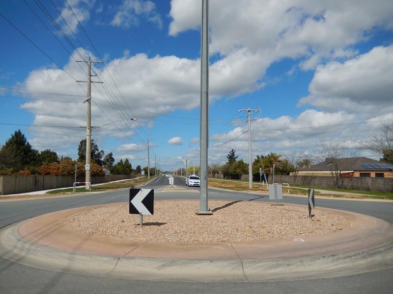 A Roundabout with a black and white arrow Pointing to the right — Mawson Constructions in Kialla, VIC