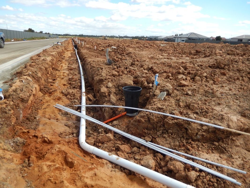 A Construction Site with a lot of Pipes in the dirt — Mawson Constructions in Kialla, VIC