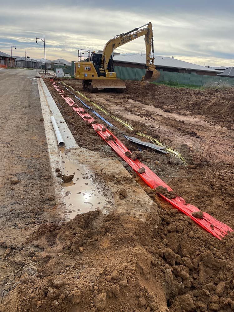 A Bulldozer is Digging a hole in the dirt on a Construction site — Mawson Constructions in Kialla, VIC