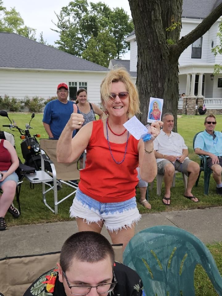 A woman is giving a thumbs up while holding a piece of paper