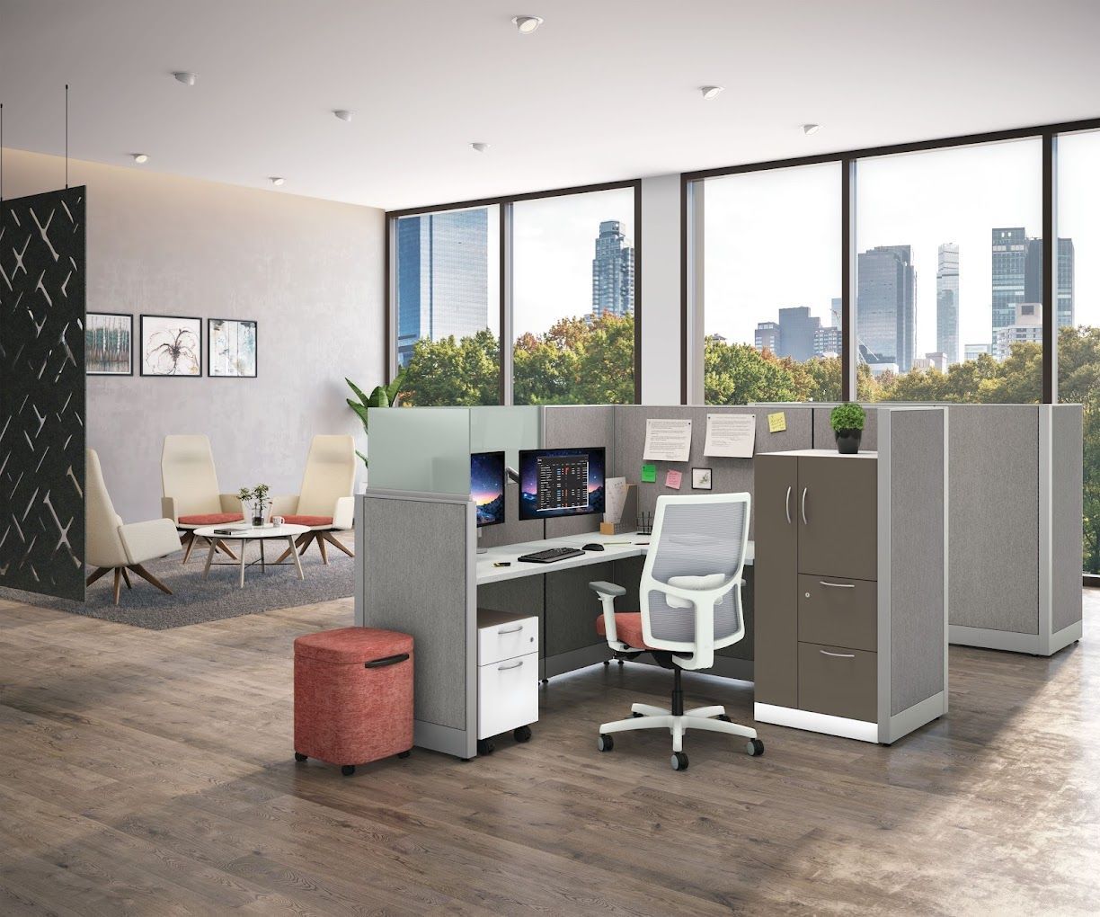 A cubicle with a desk and chair in an office with a lot of windows.