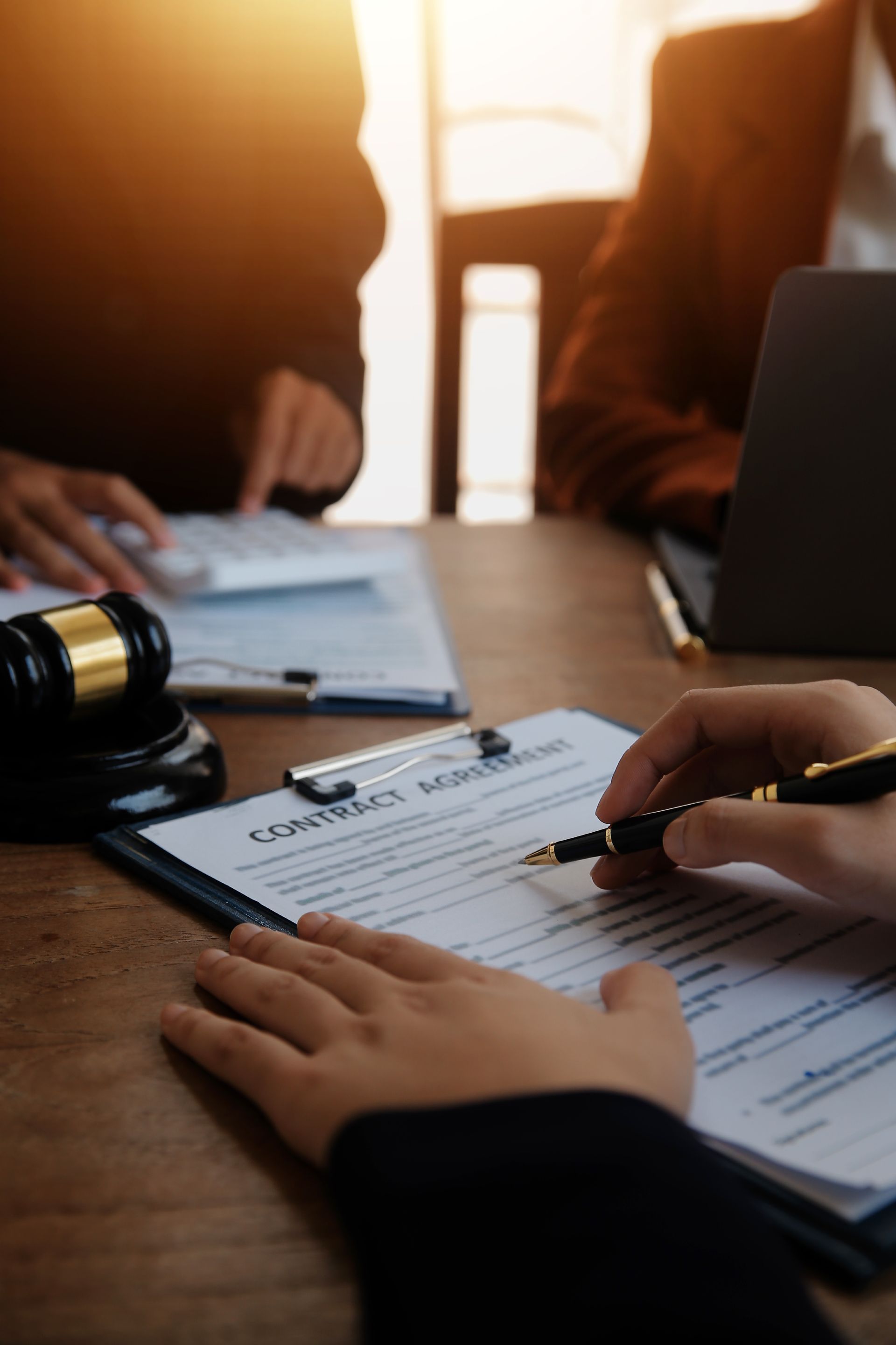 Gavel and statue of Lady Justice with scales and sword on a wooden surface, library background.