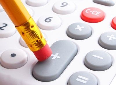 Pencil eraser pressing down on the plus sign key of a white calculator.