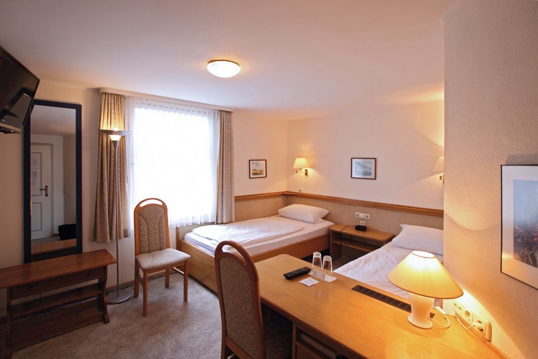 Ein Hotelzimmer mit zwei Betten und einem Schreibtisch