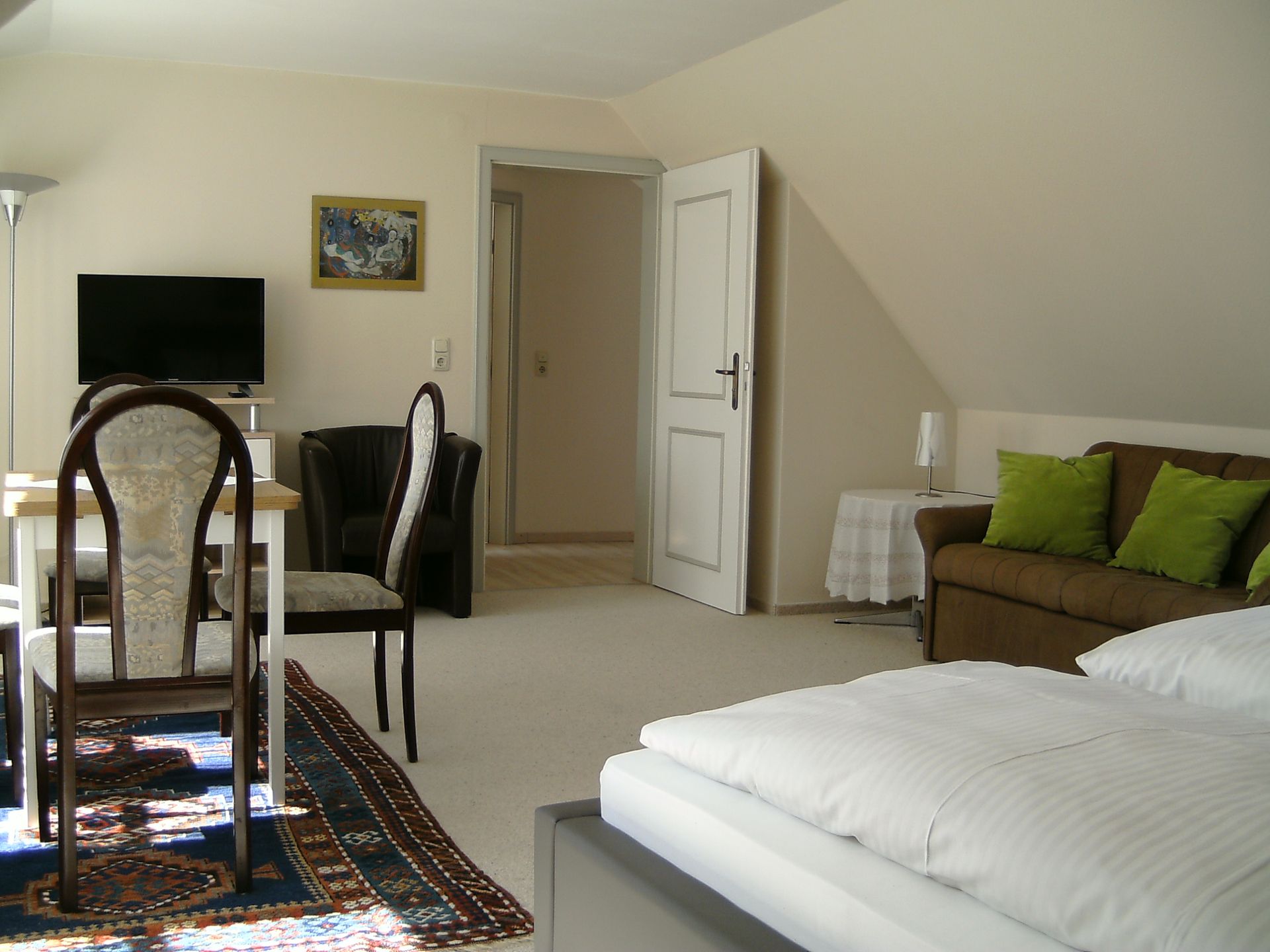 Ein Schlafzimmer mit einer Couch, einem Tisch und Stühlen