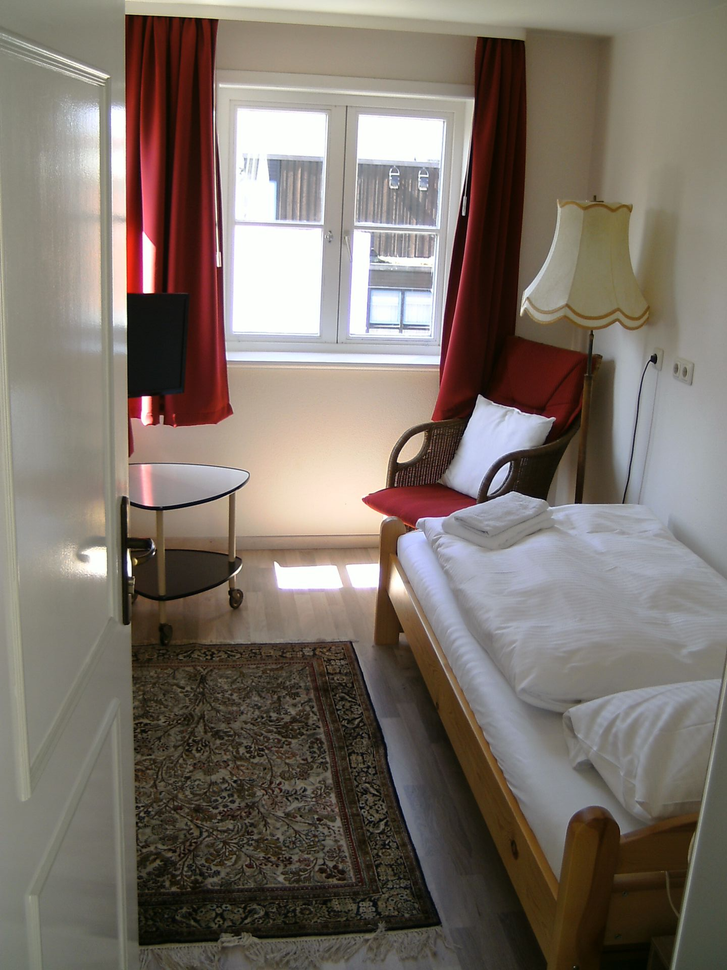 Ein Schlafzimmer mit einem Bett, einem Stuhl und einer Lampe