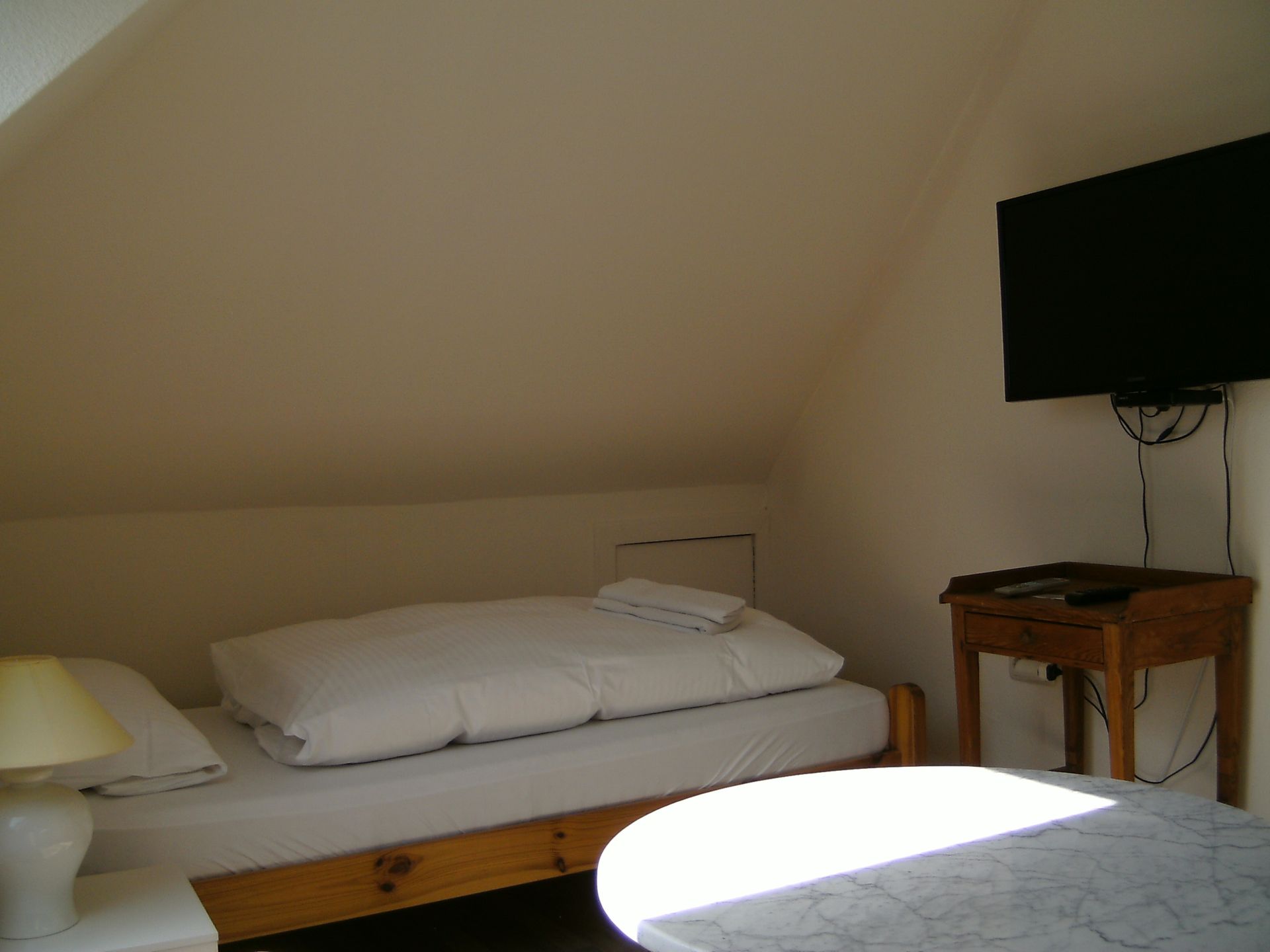 Ein Schlafzimmer mit einem Einzelbett und einem Flachbildfernseher